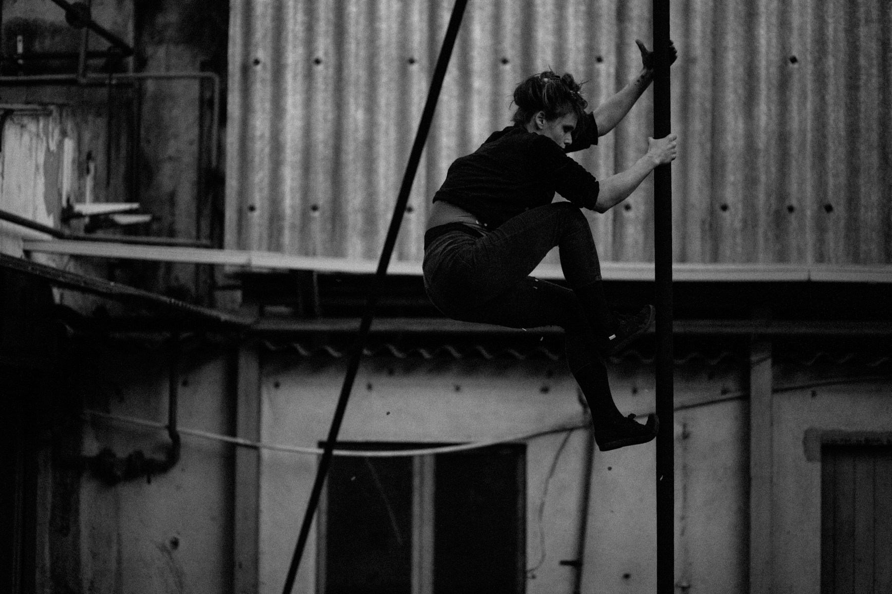 Pole artist moving through a controlled studio sequence